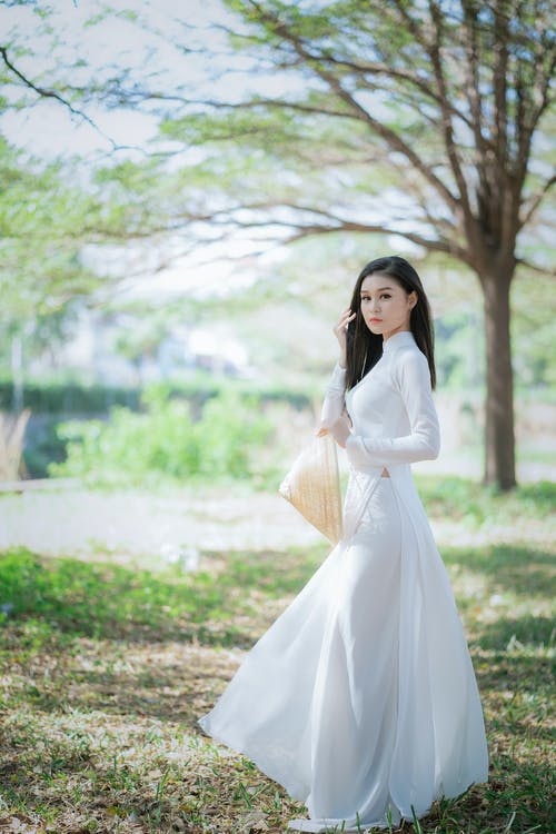 站在草地上的白色长袖连衣裙的女人 · 免费素材图片
