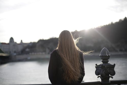 紫罗兰色外套站在水体附近的女人 · 免费素材图片