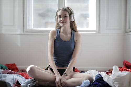 高兴的女人在家里的耳机听音乐 · 免费素材图片