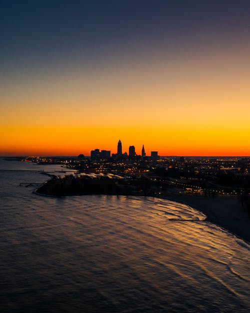 日落期间横跨水体的城市天际线 · 免费素材图片