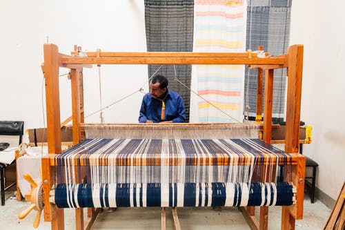 在车间的织布机上工作的民族工匠 · 免费素材图片
