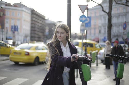 女人穿着黑色外套站在户外的浅焦点照片 · 免费素材图片