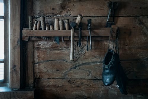 挂在架子上，在仿古木制车间的鞋匠工具 · 免费素材图片