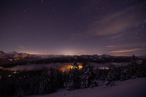 夜间树木和山脉的照片 · 免费素材图片