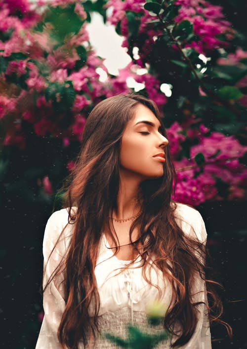 白衬衫站在红色花朵附近的女人 · 免费素材图片