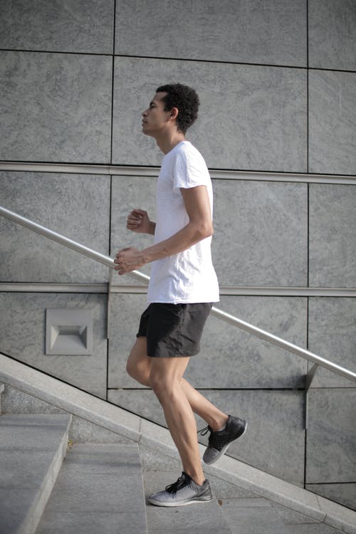 肌肉确定族裔男性运动员在大街上跑上楼梯 · 免费素材图片