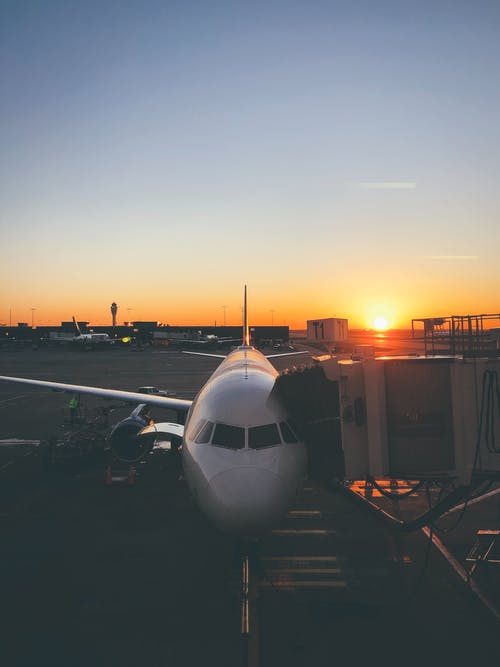 日落期间在机场上的白色飞机 · 免费素材图片