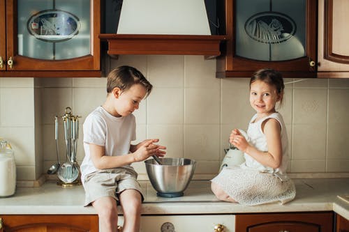 孩子们在厨房台面上玩的照片 · 免费素材图片