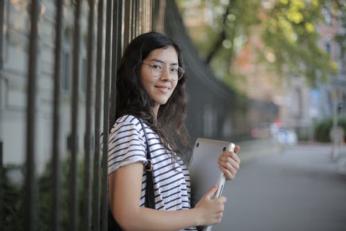 黑色和白色的条纹衬衫，拿着笔记本电脑的女人 · 免费素材图片