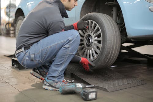 男子更换汽车轮胎 · 免费素材图片