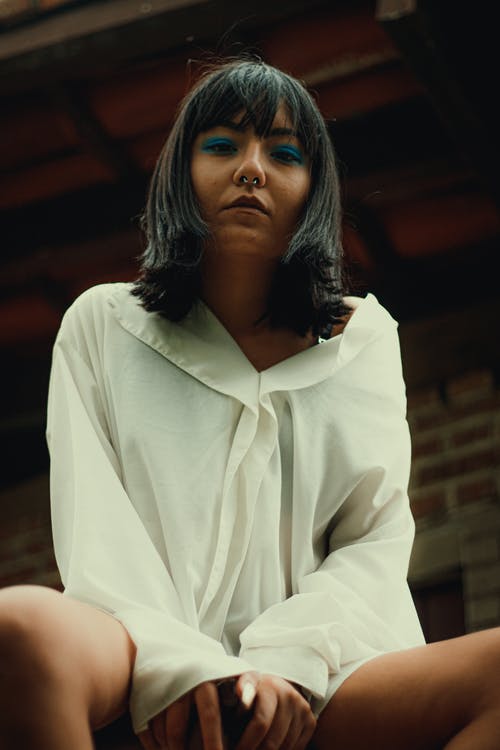 沉思时尚的族裔女人，在老房子附近的台阶上冷 · 免费素材图片