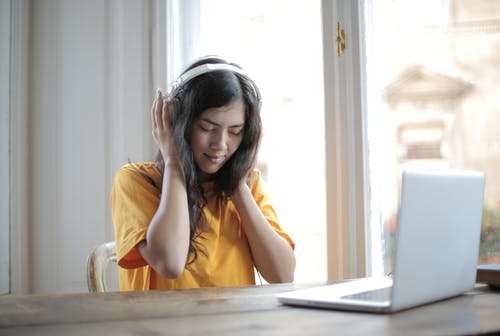 坐在桌旁的黄色衬衫的女人 · 免费素材图片