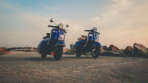 蓝色轻便摩托车停在农村的空路上 · 免费素材图片