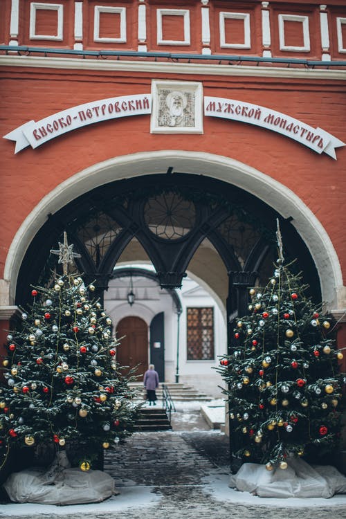 老教堂门面与拱入口附近的圣诞树 · 免费素材图片