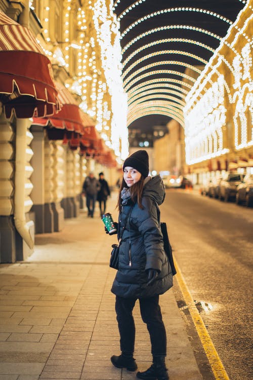 黑夹克站在人行道上的女人 · 免费素材图片