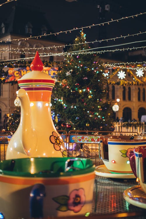 节日的旋转木马与巨型茶壶和杯子在公园里装饰着圣诞节的夜晚风格 · 免费素材图片