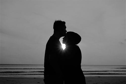 男人和女人站在海滩上的剪影 · 免费素材图片