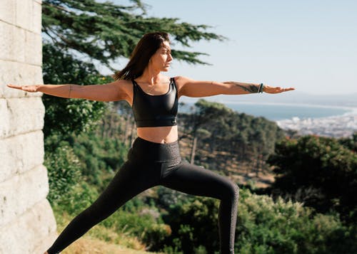 黑色运动胸罩和黑色紧身裤做瑜伽的女人 · 免费素材图片