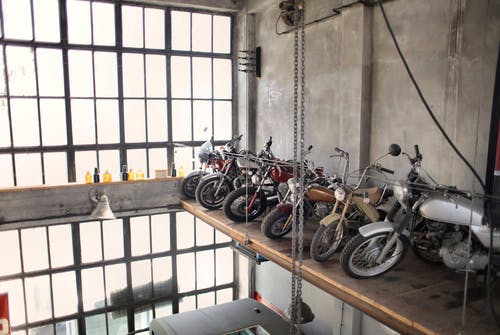 复古摩托车成排停在车库的特殊平台上 · 免费素材图片