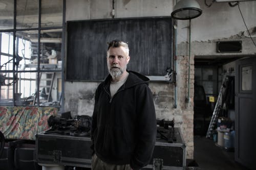 站在黑表附近的黑夹克的男人 · 免费素材图片