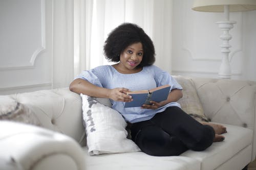 蓝色衬衫和黑色的裤子，坐在白色的沙发上的女人 · 免费素材图片