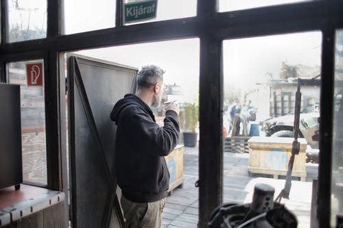 站在门口的黑夹克的男人 · 免费素材图片