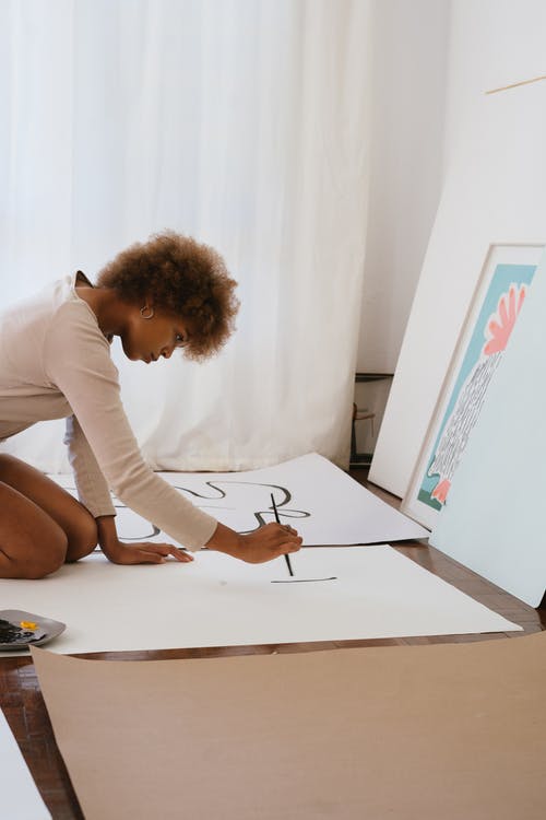 女人画在白色插图板上的照片 · 免费素材图片