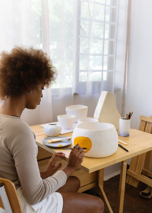 集中在手工粘土碗上痛苦的黑人女性陶艺家 · 免费素材图片
