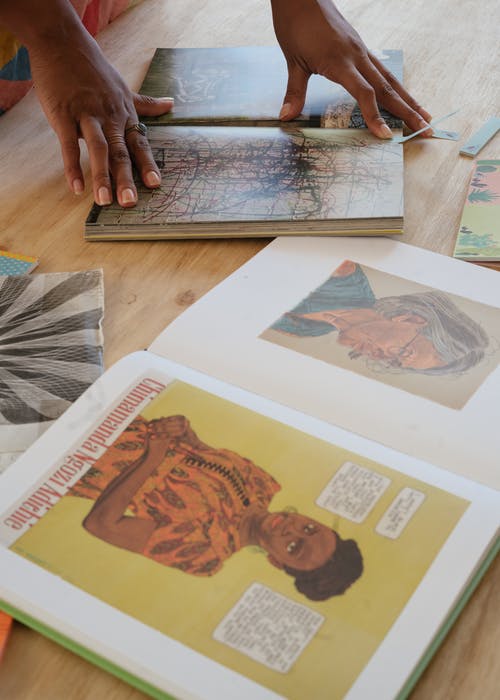 族裔女人翻书的页面与粘书签 · 免费素材图片