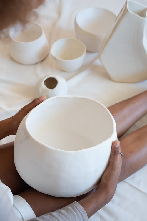 黑色工匠与手工陶瓷碗在车间 · 免费素材图片