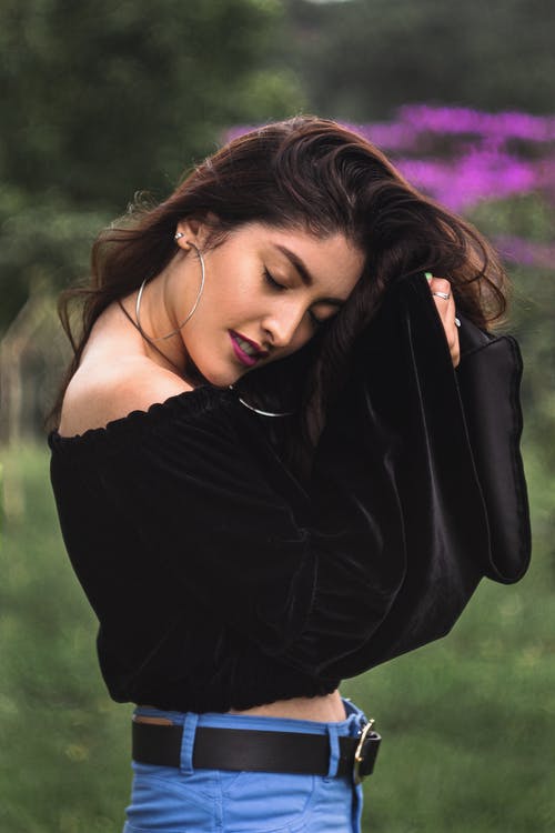 黑掉肩上衣和蓝色牛仔裤的女人 · 免费素材图片