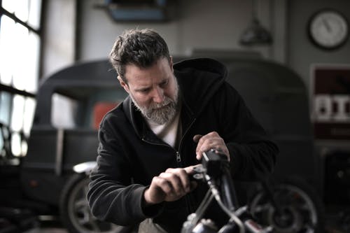 修理摩托车的残酷人在车间 · 免费素材图片