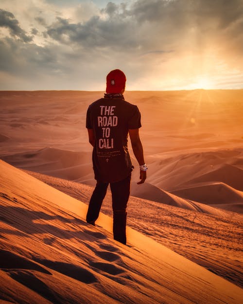 男子站在沙漠上的照片 · 免费素材图片