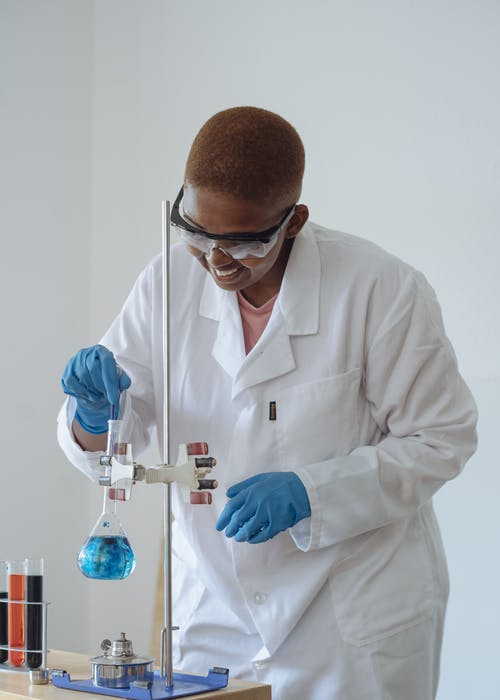 在现代实验室中检查化学液体的微笑科学家 · 免费素材图片