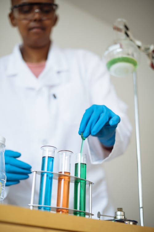作物实验室技术员在实验室的试管中使用多彩的试剂 · 免费素材图片