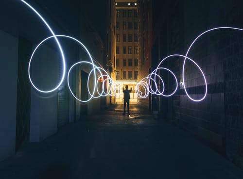 在黑暗的街道上用手电筒做圈子的人的剪影 · 免费素材图片