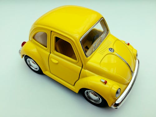 白色背景上的黄色大众甲壳虫玩具车 · 免费素材图片