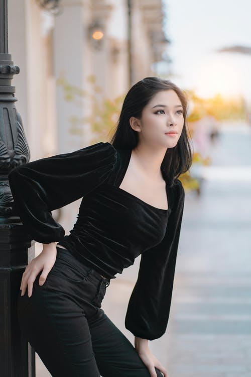 优雅的亚洲女人，优雅地站在街道的人行道上 · 免费素材图片
