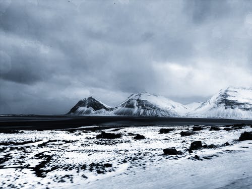 白雪皑皑的山区地形对多云的天空 · 免费素材图片