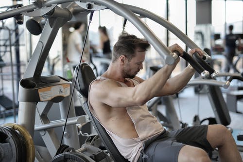 用肩膀压机在健身房锻炼的肌肉男 · 免费素材图片