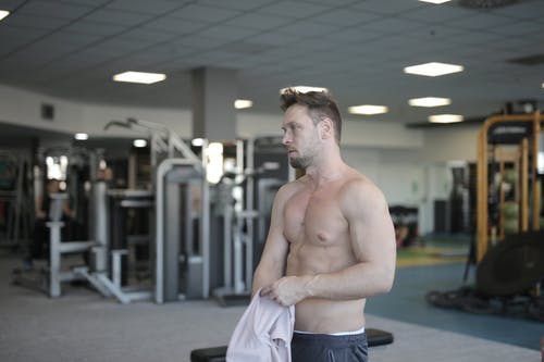 汗湿的赤膊运动员在健身房训练后休息 · 免费素材图片