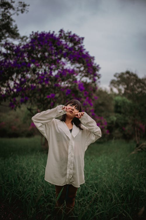 米色大衣遮住她的脸，她的手的女人 · 免费素材图片