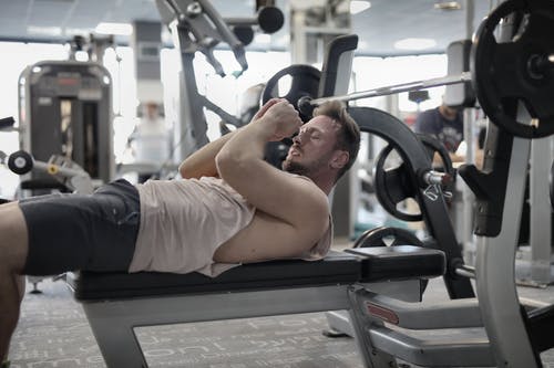 集中肌肉型男准备在健身房卧推 · 免费素材图片