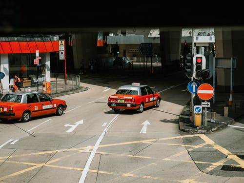 在城市的街道上行驶的红色汽车 · 免费素材图片