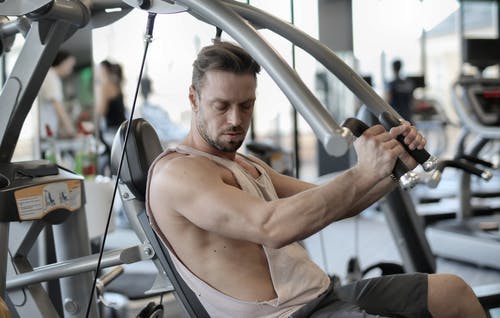 在健身房锻炼与金属机的适合男性健美 · 免费素材图片