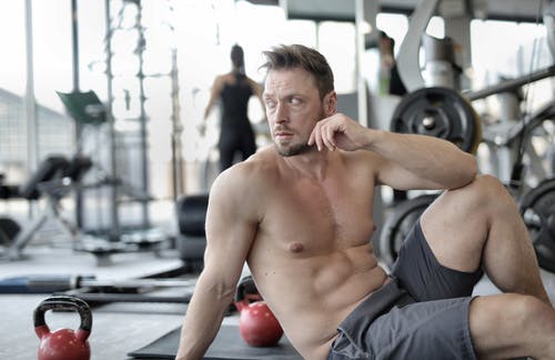 坐在黑色垫子上的灰色短裤的裸照人 · 免费素材图片