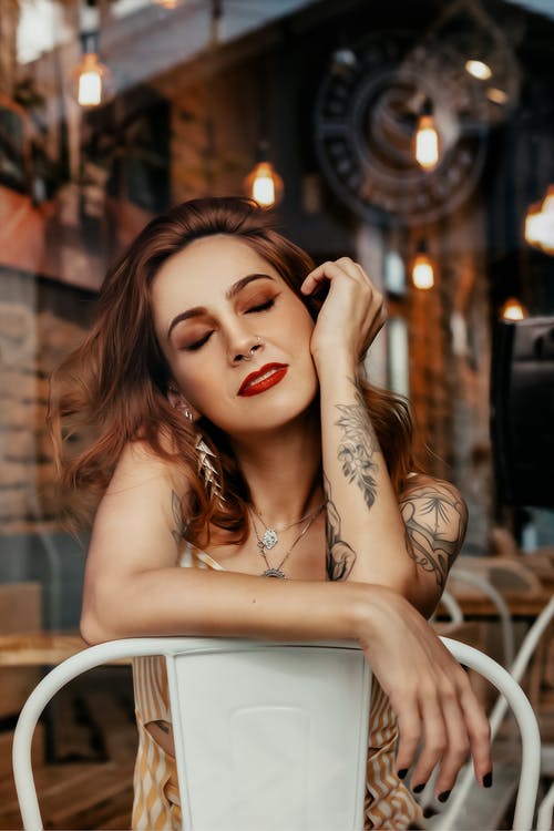 美满的年轻纹身的女人在街边咖啡馆冷 · 免费素材图片