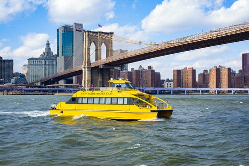 在桥附近的河上航行的黄色船只船 · 免费素材图片