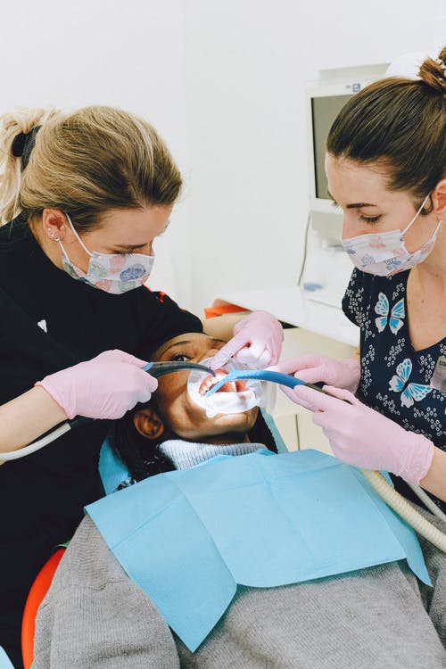 女牙医助理治疗病人在诊所 · 免费素材图片
