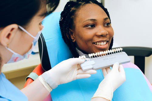 现代诊所的微笑族裔女士访问牙医 · 免费素材图片